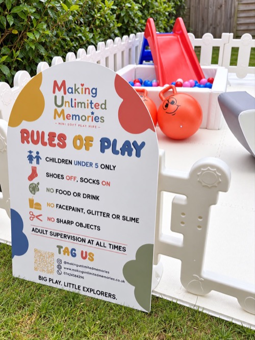 M.U.M rules of play sign with ball pit and ride-on hoppers in a garden set-up