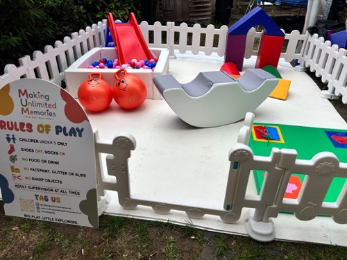 Full mini park layout in a garden, with ball pit, slide, ride-on hoppers and soft play blocks