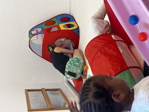 Children playing in the pop-up tunnel and play tent indoors