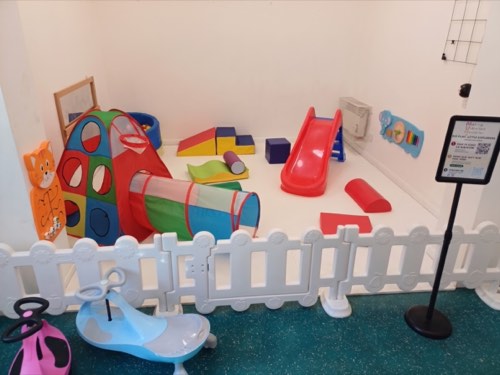 Indoor venue soft play setup with slide, tunnel and ride-on cars