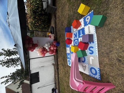 Soft play blocks and alphabet activity mat set up in a garden